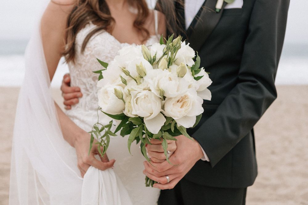 Close-up of a white floral wedding bouquet on a Malibu beach captured on film.
