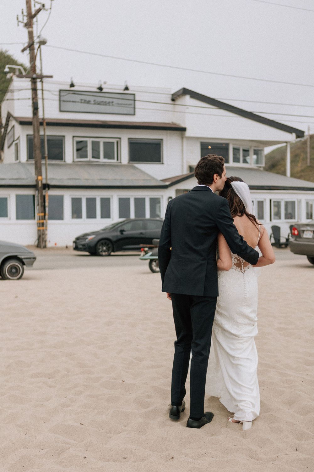 Couple walking along the Malibu coast to their Sunset Restaurant wedding reception.