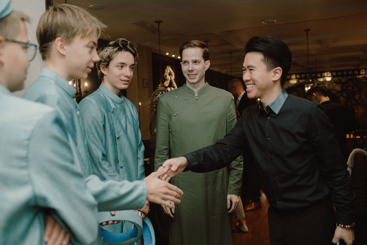 A group wearing matching outfits share an animated conversation at an indoor gathering.