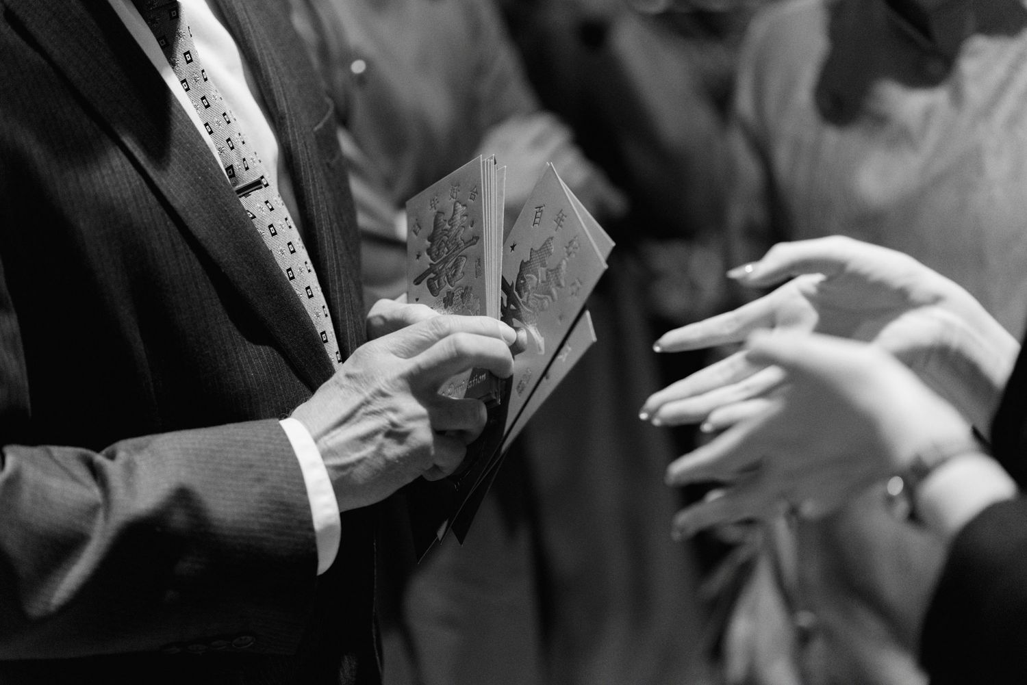 Guests toasting with small red glasses at an elegant indoor event.