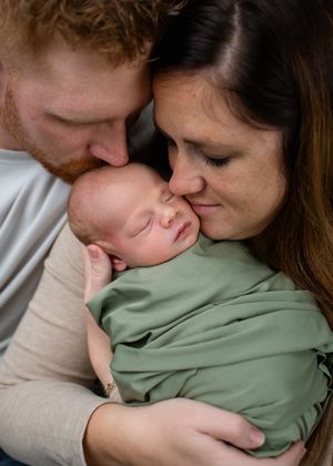 Parent and child share a tender bonding moment with cuddles and kisses while wearing casual attire.