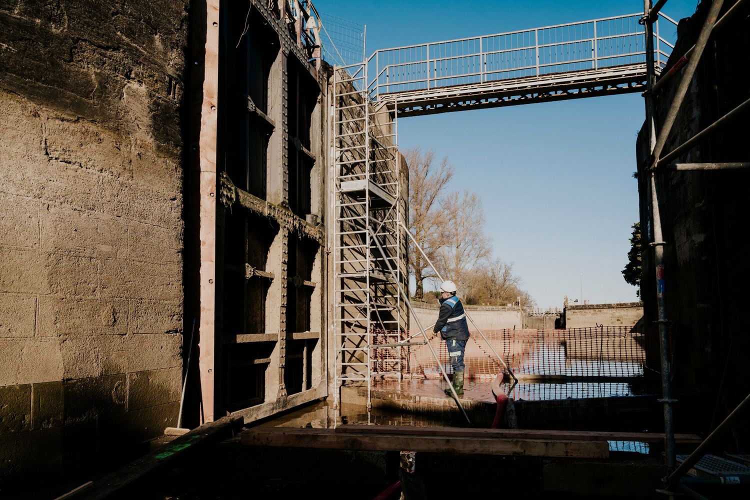 Photographe professionnel Toulouse: Technicien hydraulique dans la Montagne Noire qui vérifie les vannes d’une écluse