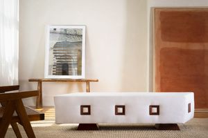 Modern minimalist room interior with light beige walls and hardwood floor showing empty space and natural lighting.