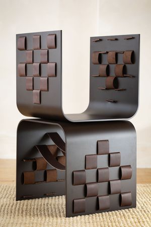 A series of progressive shots showing a modern black sculptural chair design with geometric cutouts against a neutral background.