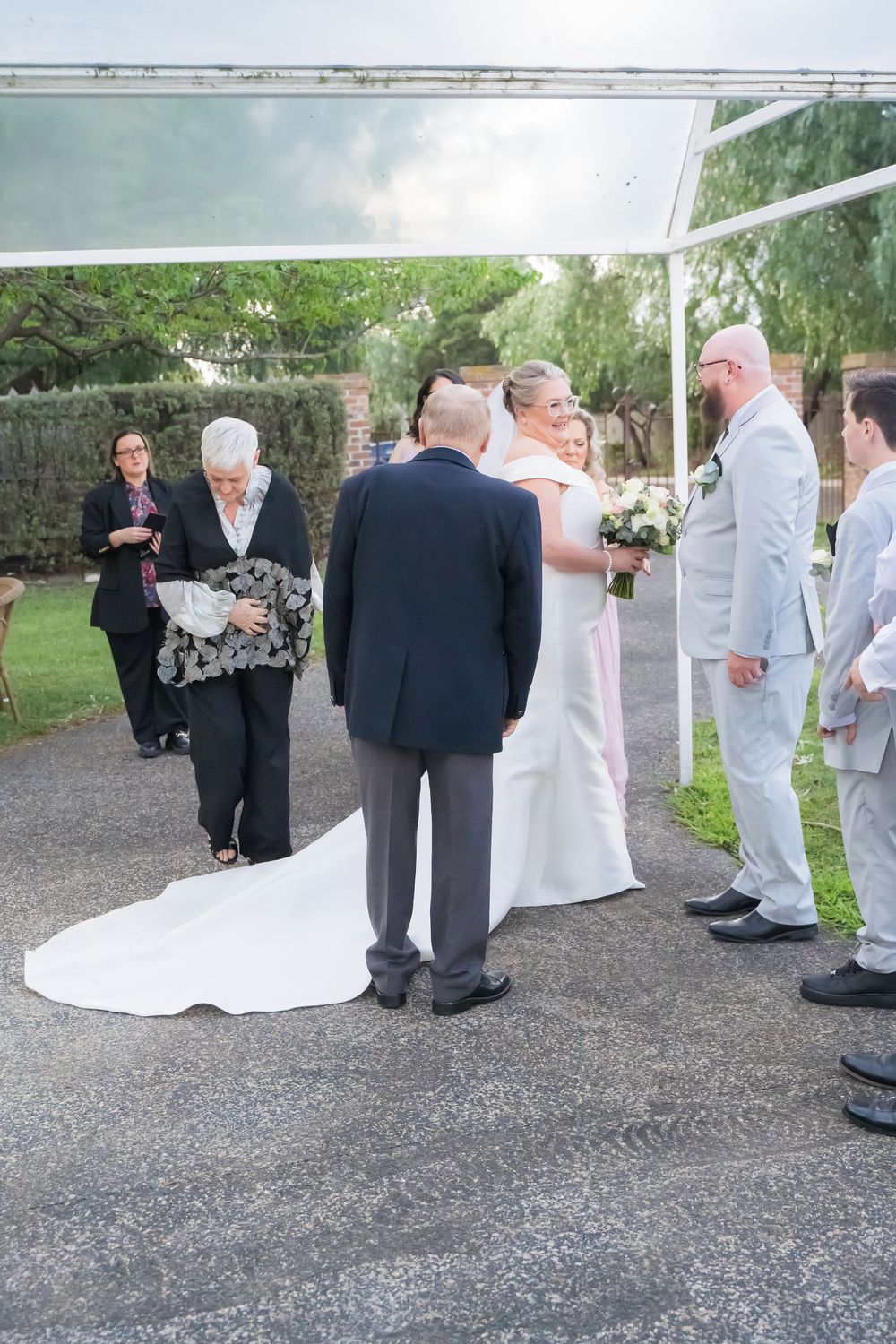 A sequence of candid wedding photos showing guests chatting and mingling on a gravel path during the celebration.