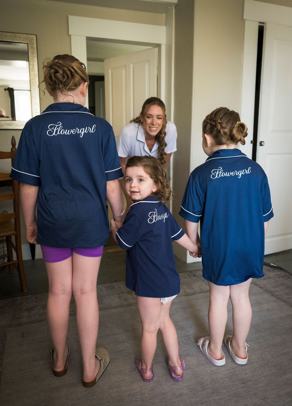 Back view of matching navy bridesmaid outfits with monogrammed text.