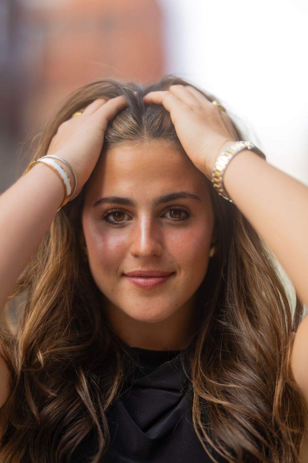 Progressive close-up shots showing someone with flowing brown hair wearing a black high-neck top.
