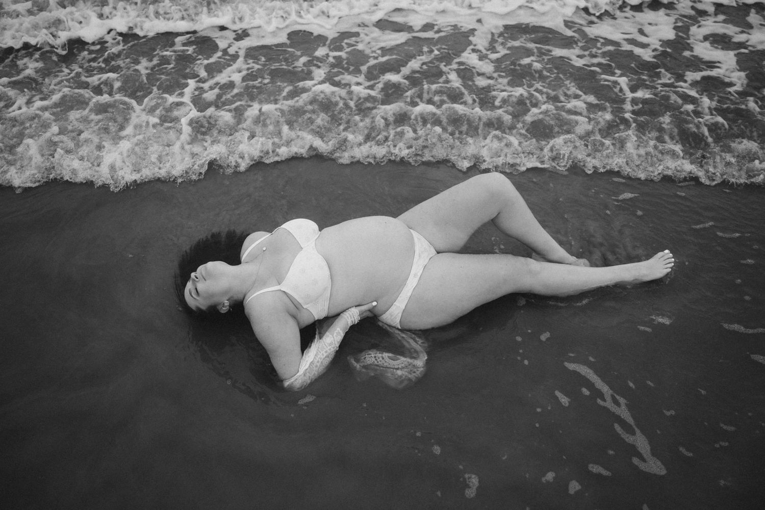 Black and white photos of waves washing over beach shore in dramatic sequence.