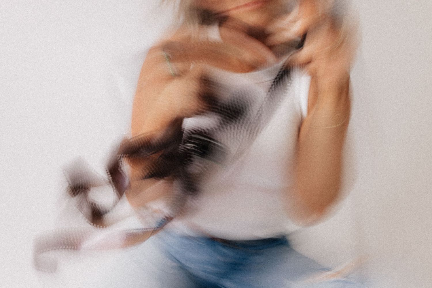 Motion-blurred artistic boudoir photography series captures ethereal movement in soft muted tones.