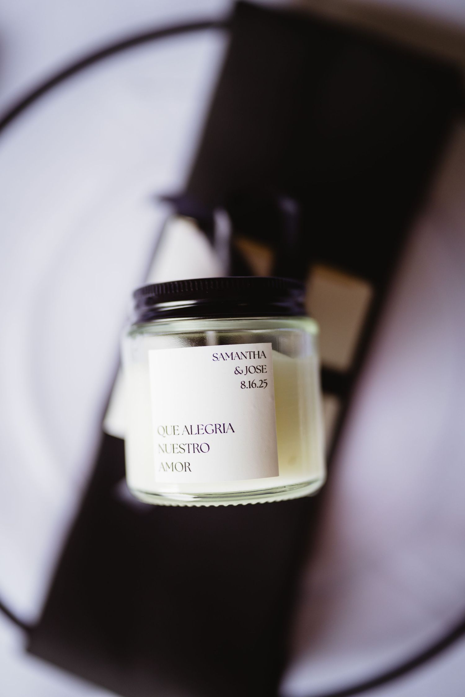 Close up macro shots of candle jar labels showing minimalist modern text labels against blurred backgrounds.