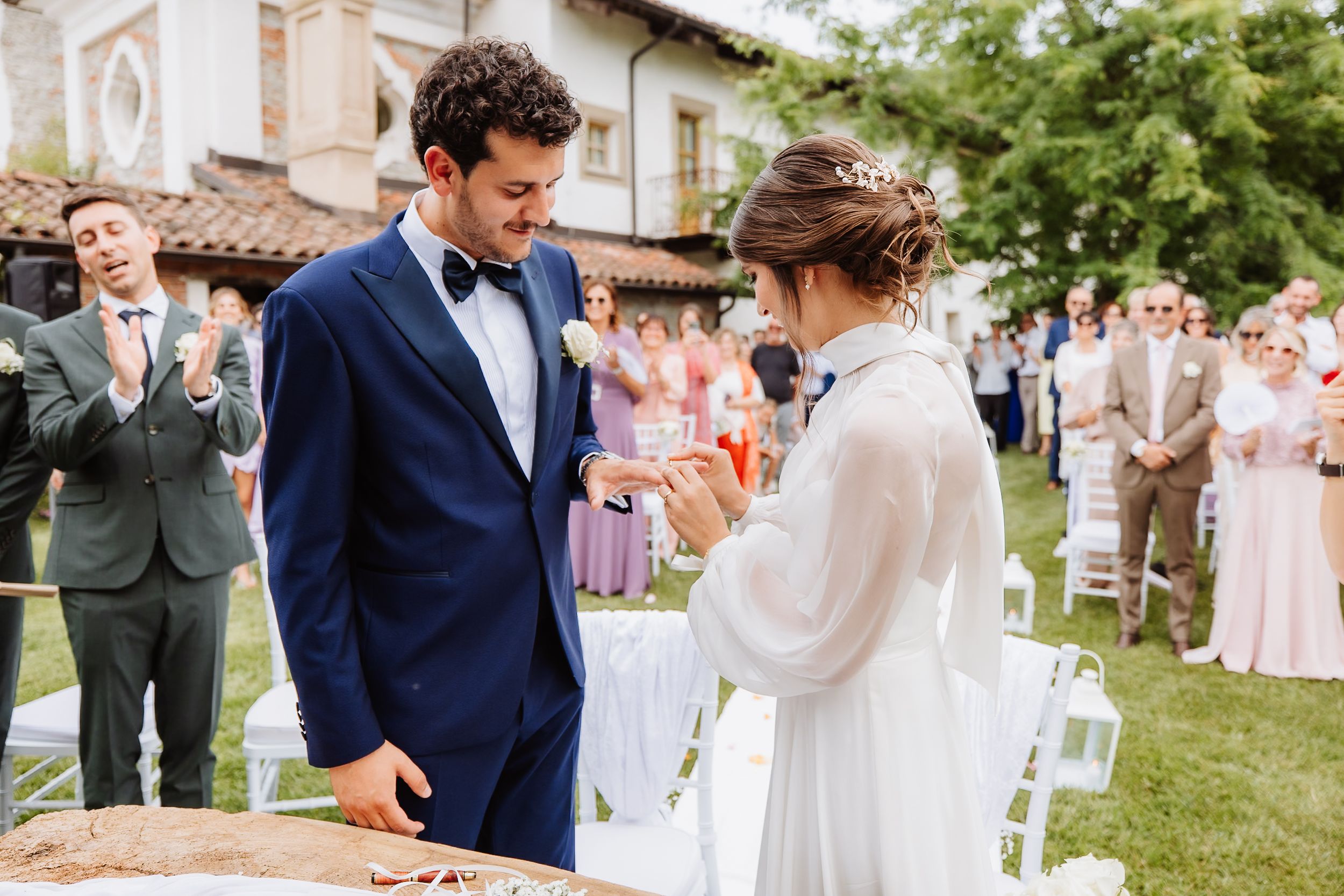 A couple shares an intimate dance during their outdoor garden wedding celebration wearing navy and white attire.