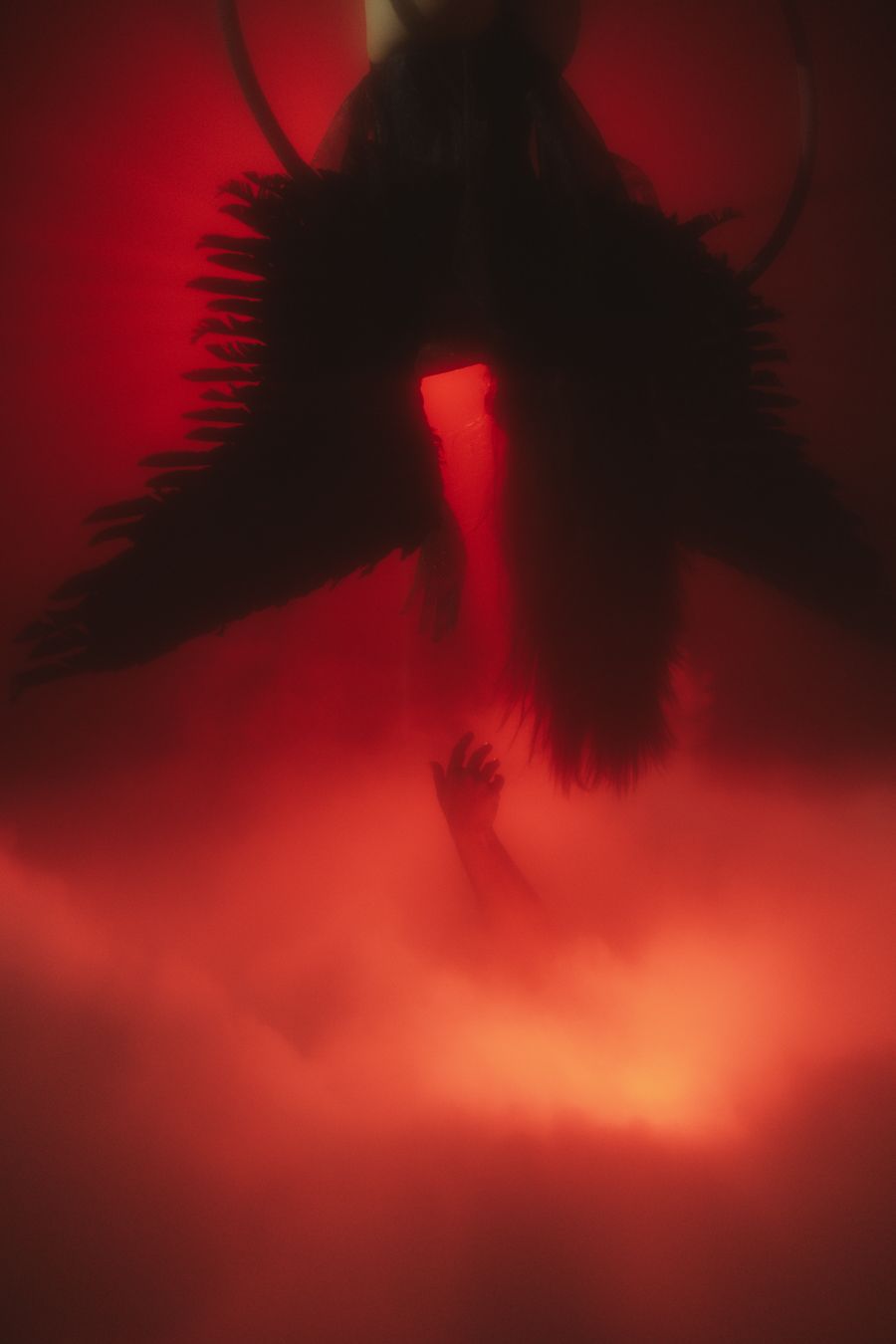 Winged aerial performer suspended in red haze, dramatic editorial capture for stage artists, Mannyportraits Ft Lauderdale cinematic photo.