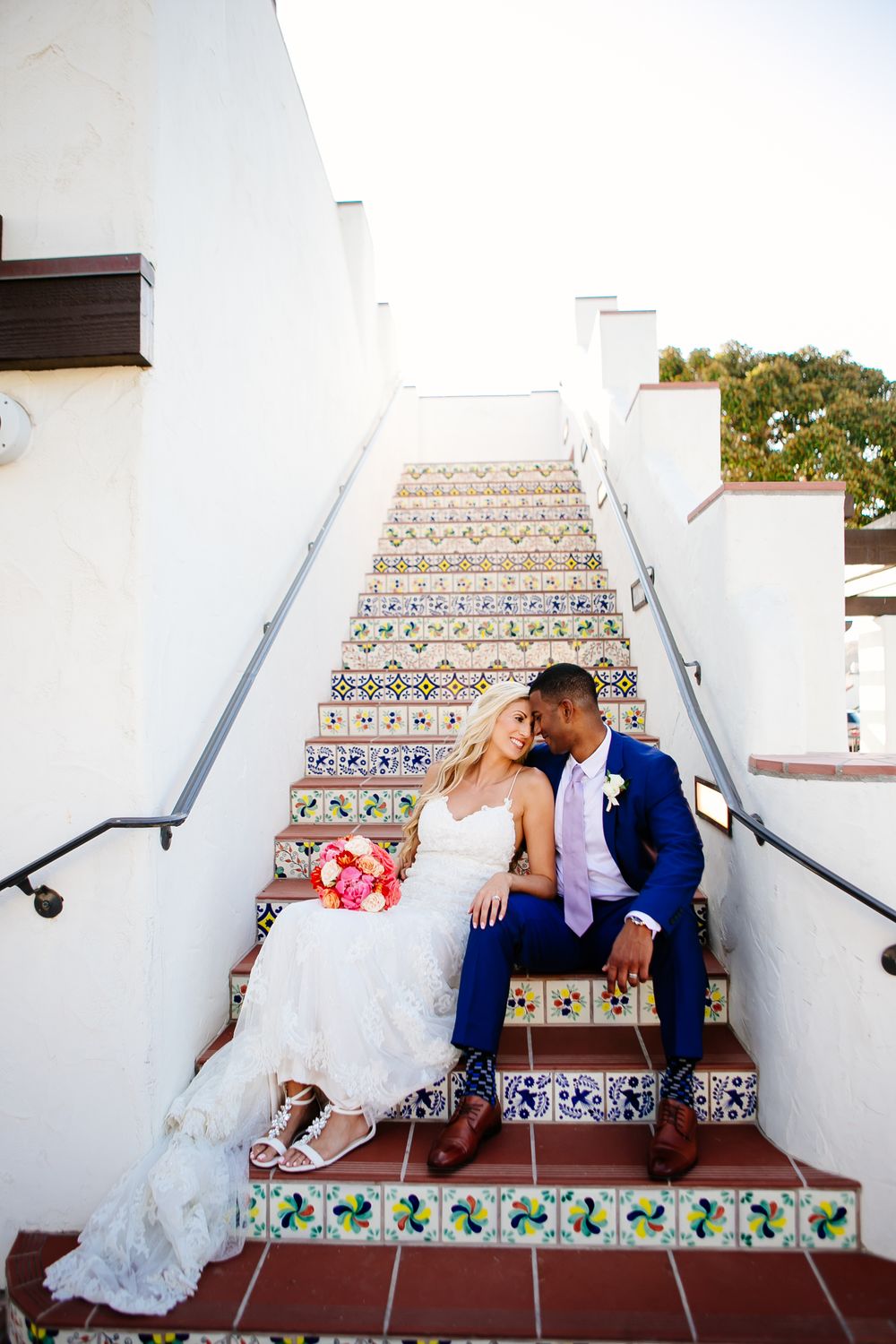 Newlywed couple poses on stairs for Wedding Photos at Ole Hanson Beach Club Wedding in San Clemente, California.