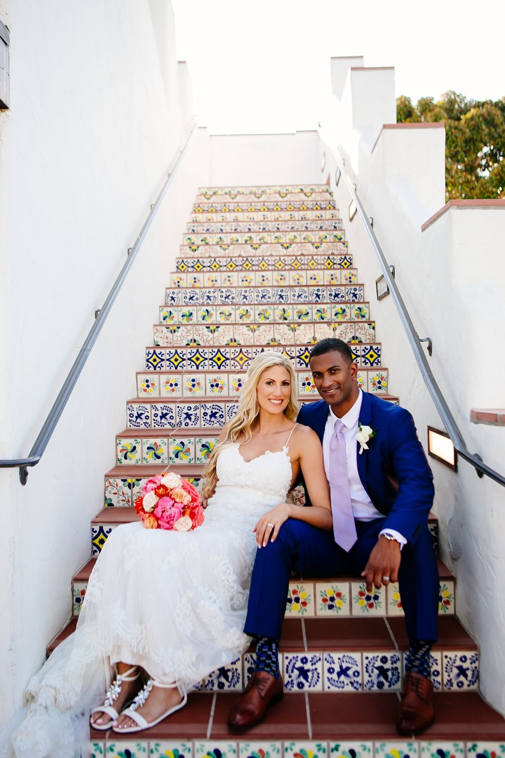 Couple poses on stairs for Wedding Photos at Ole Hanson Beach Club Wedding in San Clemente, California.