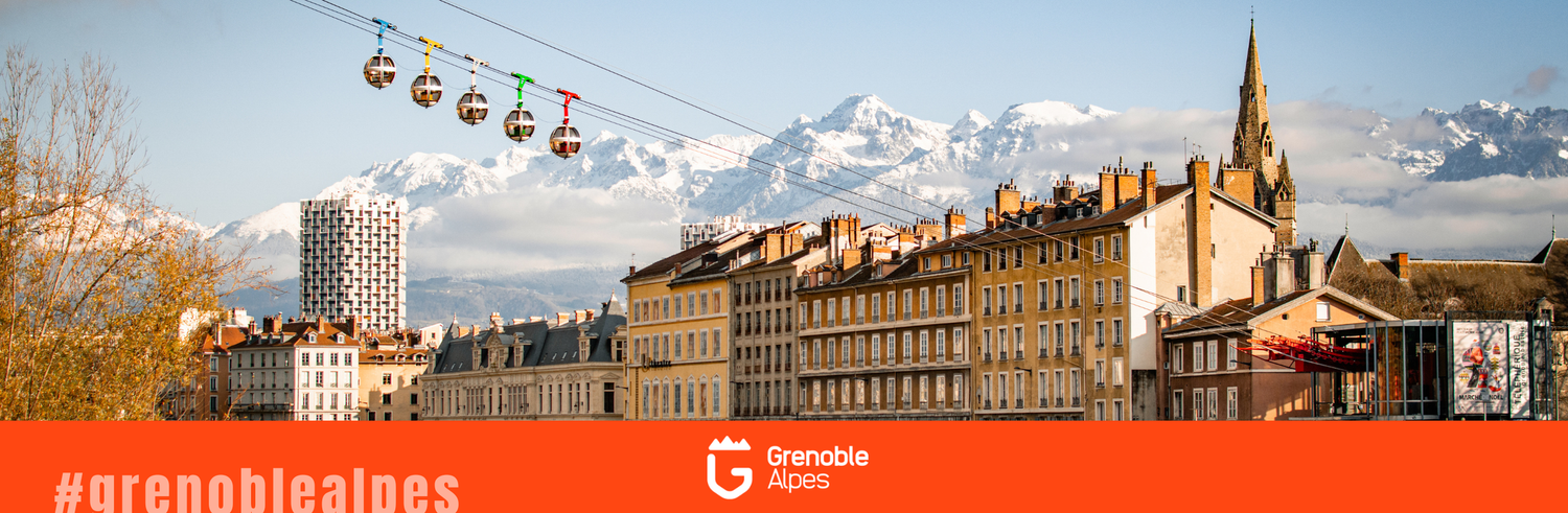 Scenic panoramic view of a city skyline with cable cars, mountain peaks, and historic architecture against a cloudy sky.