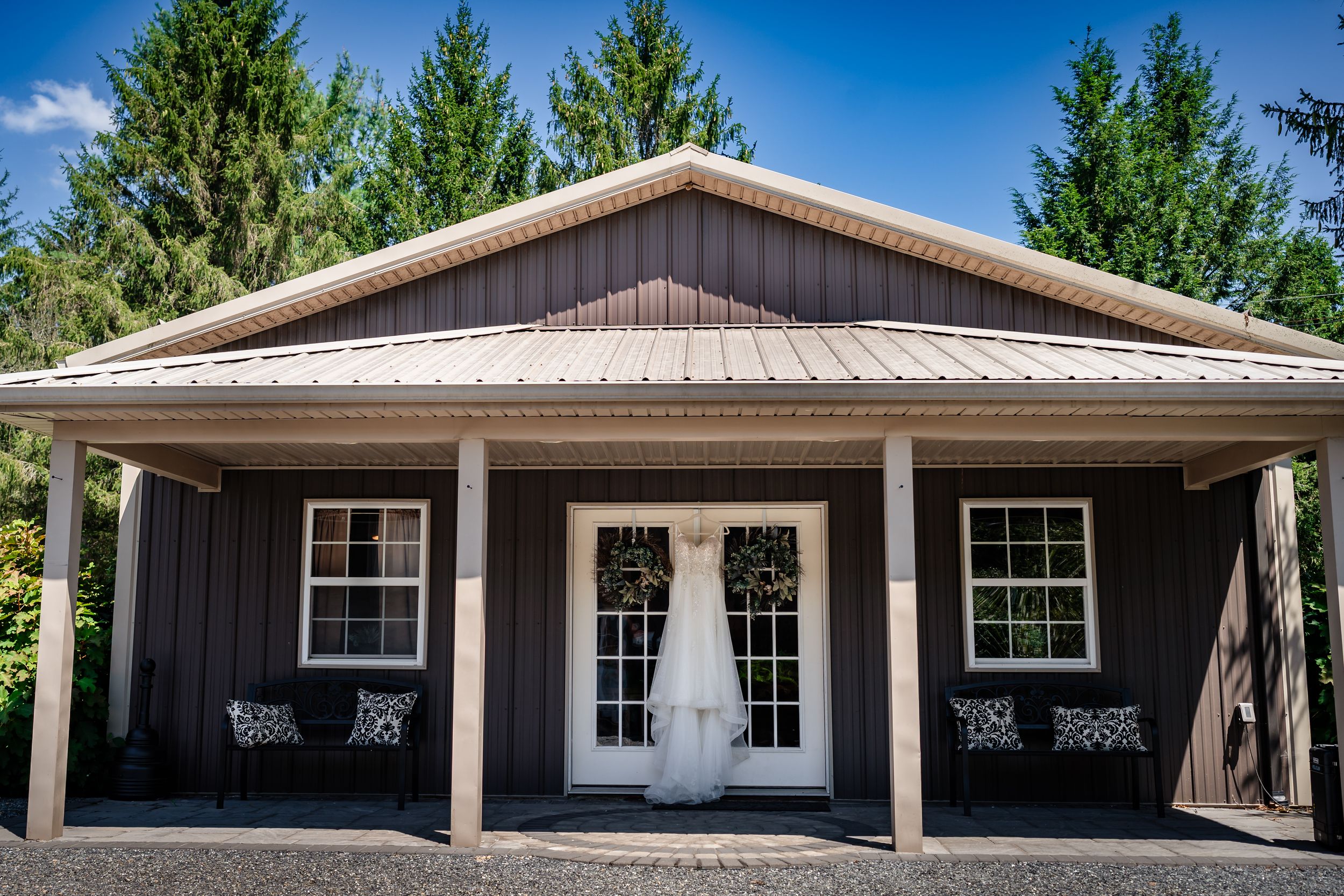Exterior view of a modern ranch-style venue with white trim and multiple windows.