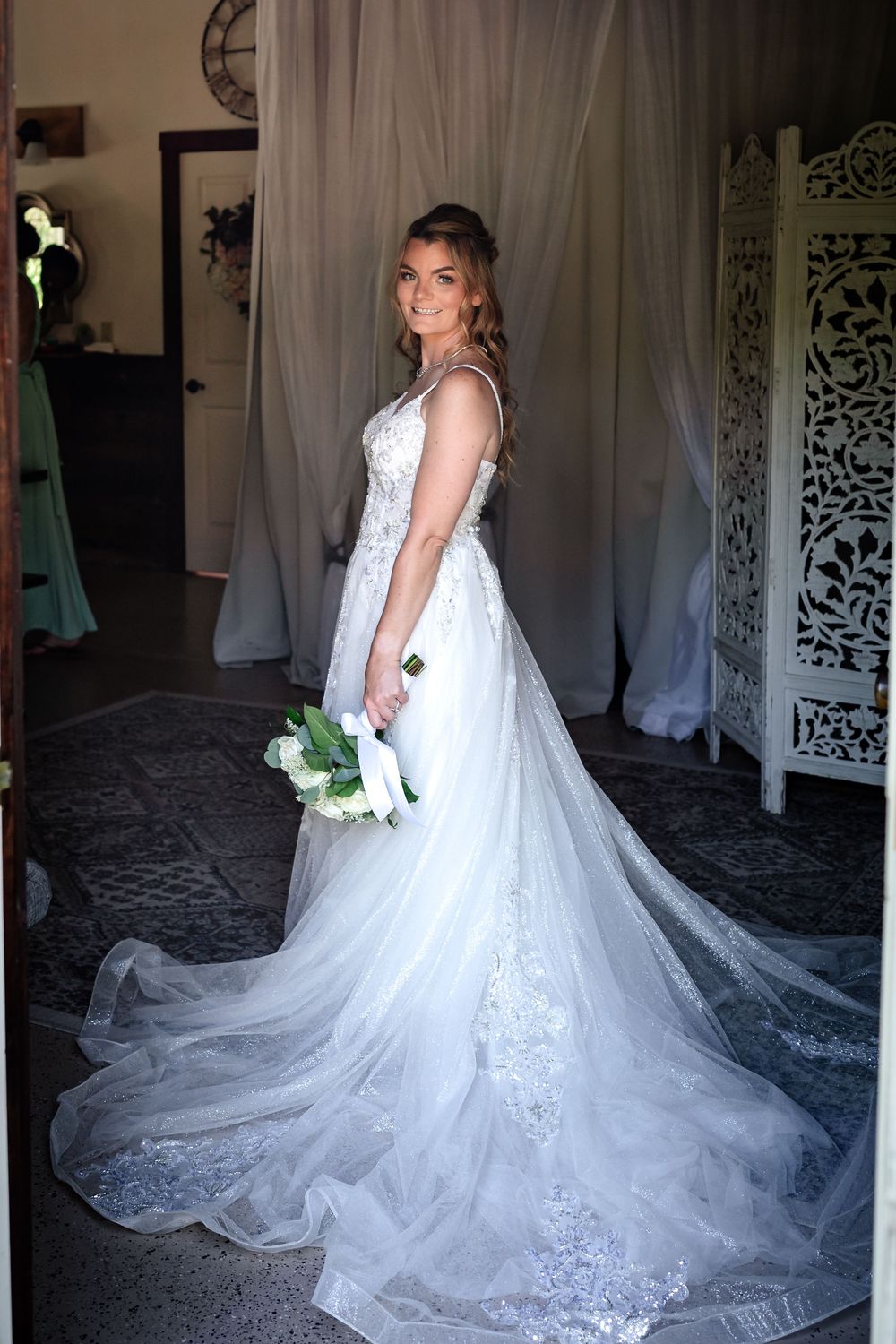 Stunning bridal portrait showcasing a lace wedding gown with cathedral length train.
