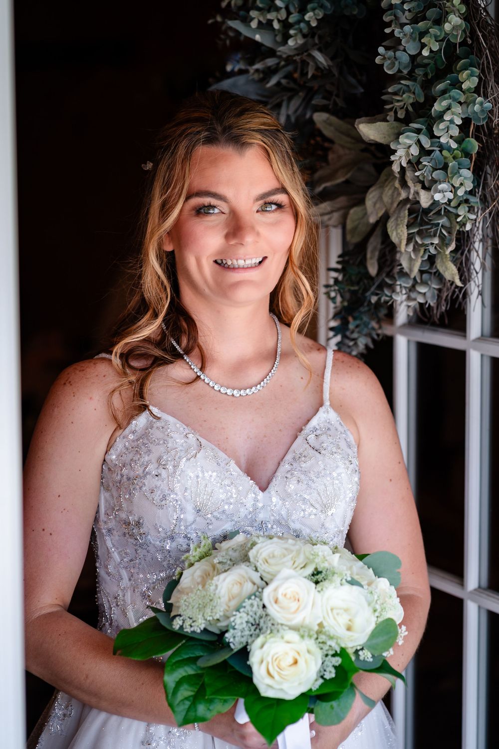 Close-up bridal portraits with white rose bouquet and sparkling jewelry.