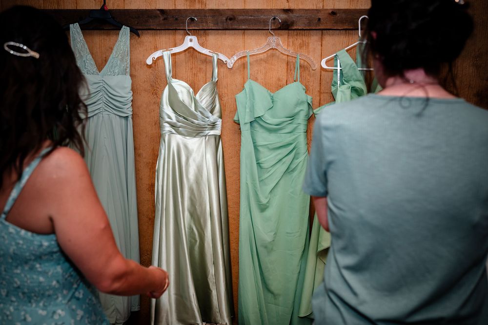 Mint green and silver bridesmaid dresses hanging on display before the wedding.