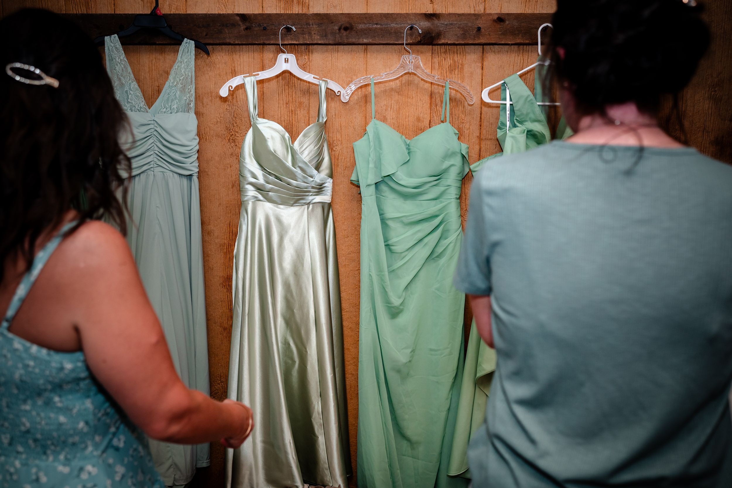 Mint green and silver bridesmaid dresses hanging on display before the wedding.