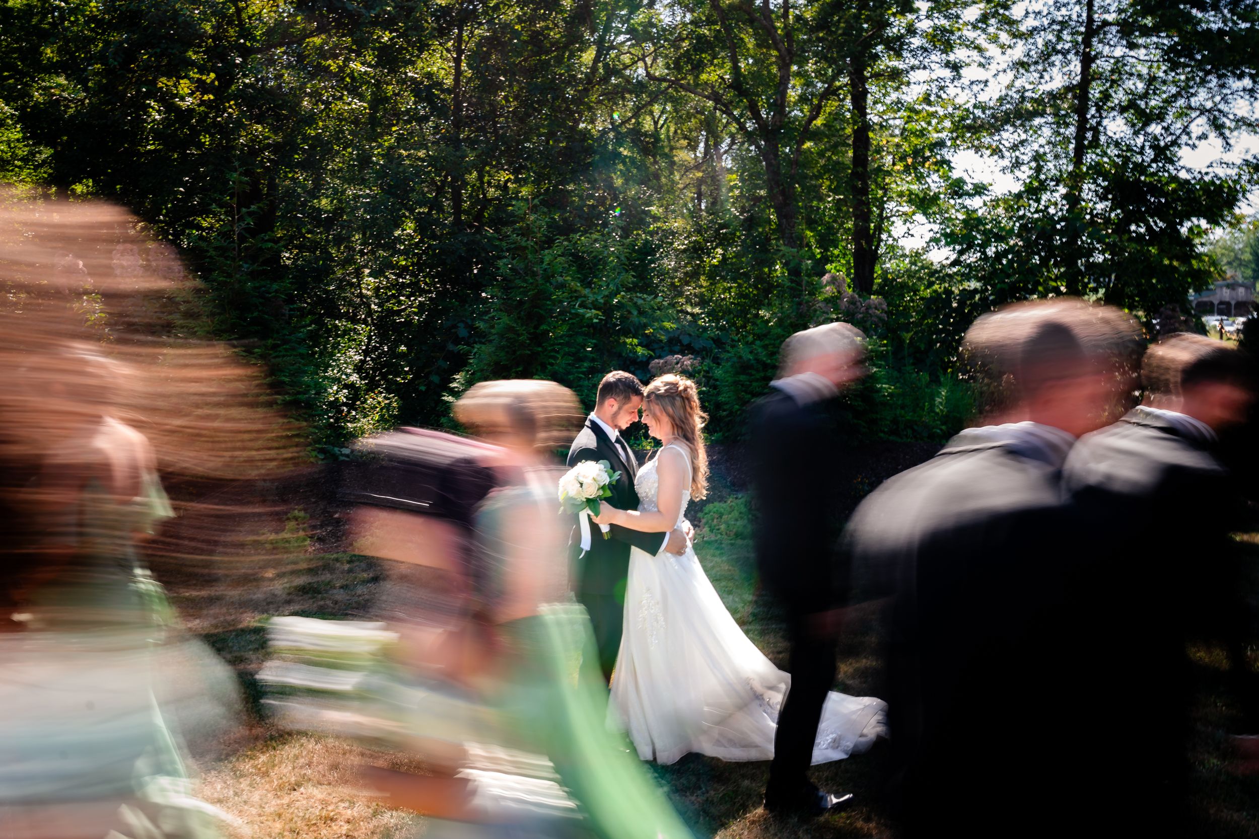 Motion blur captures dancing and movement at outdoor wedding reception.