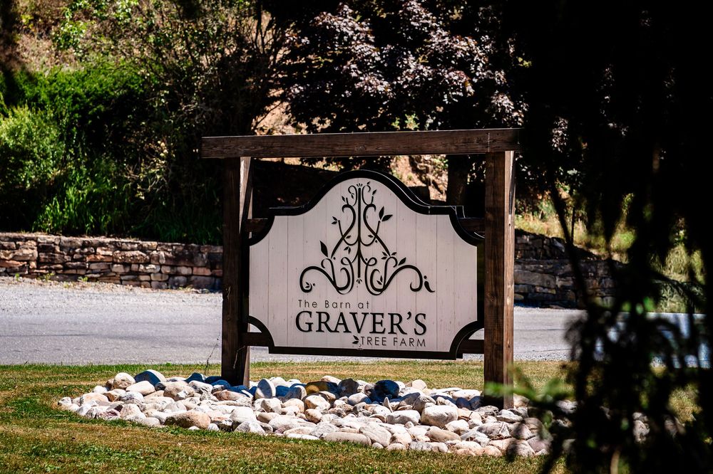 Rustic outdoor venue entrance with stone landscaping and decorative signage.