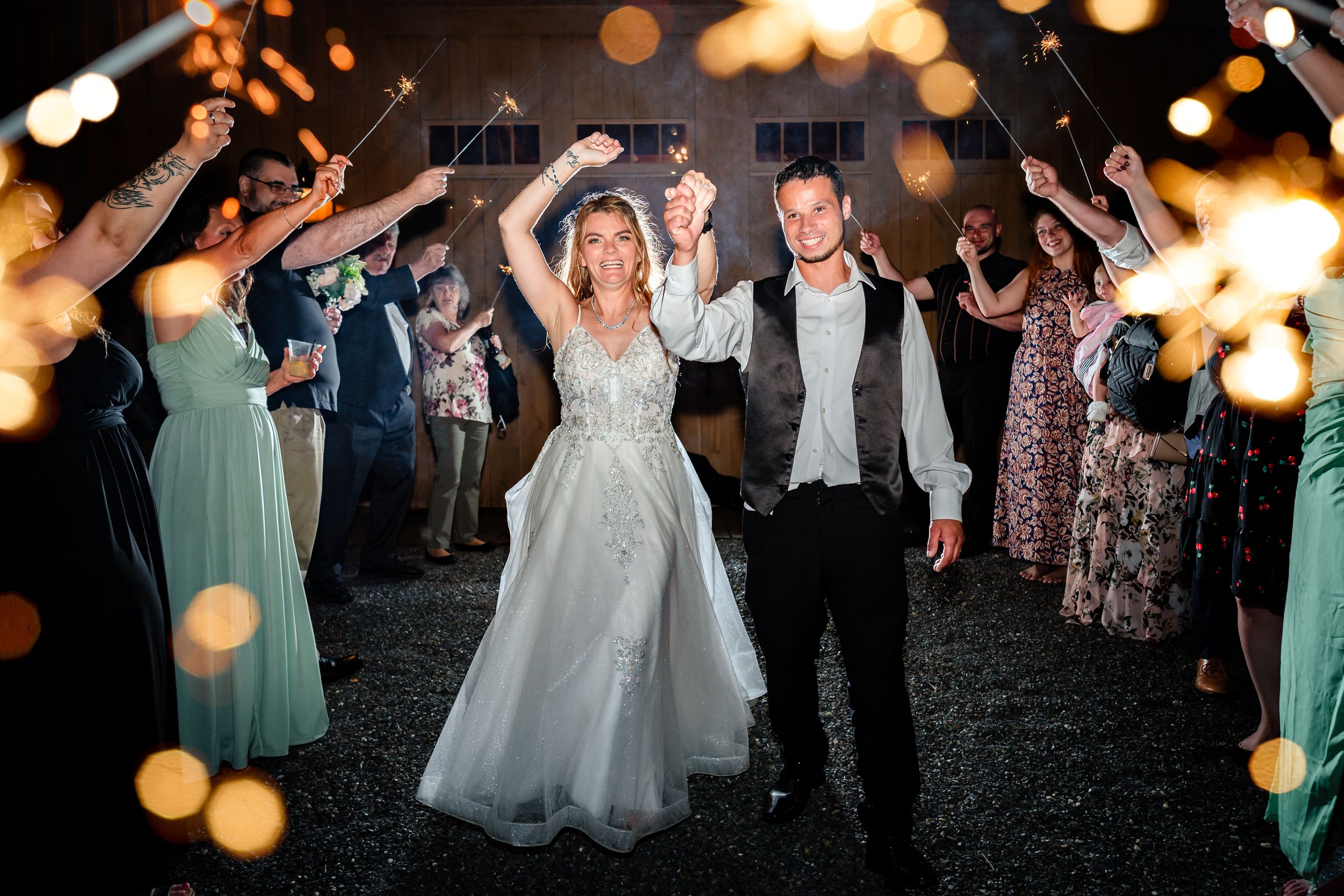 Wedding reception dance floor filled with guests celebrating under glowing string lights.