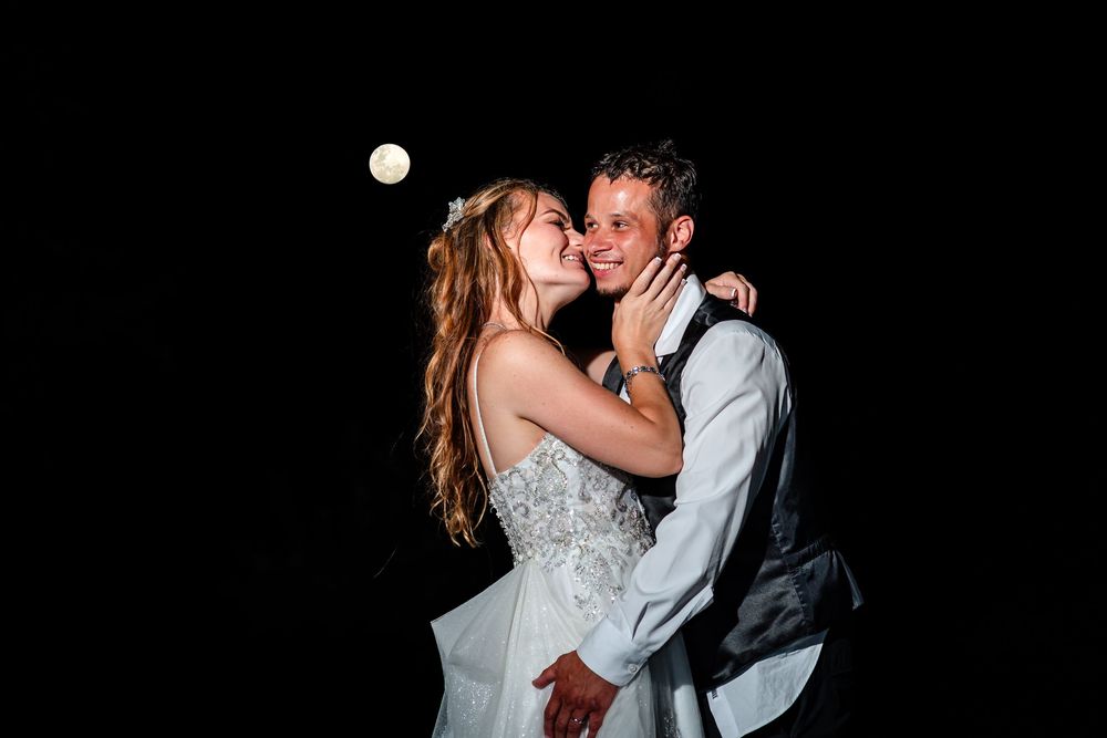 Romantic dance moment captured in dramatic black and white lighting at wedding reception.