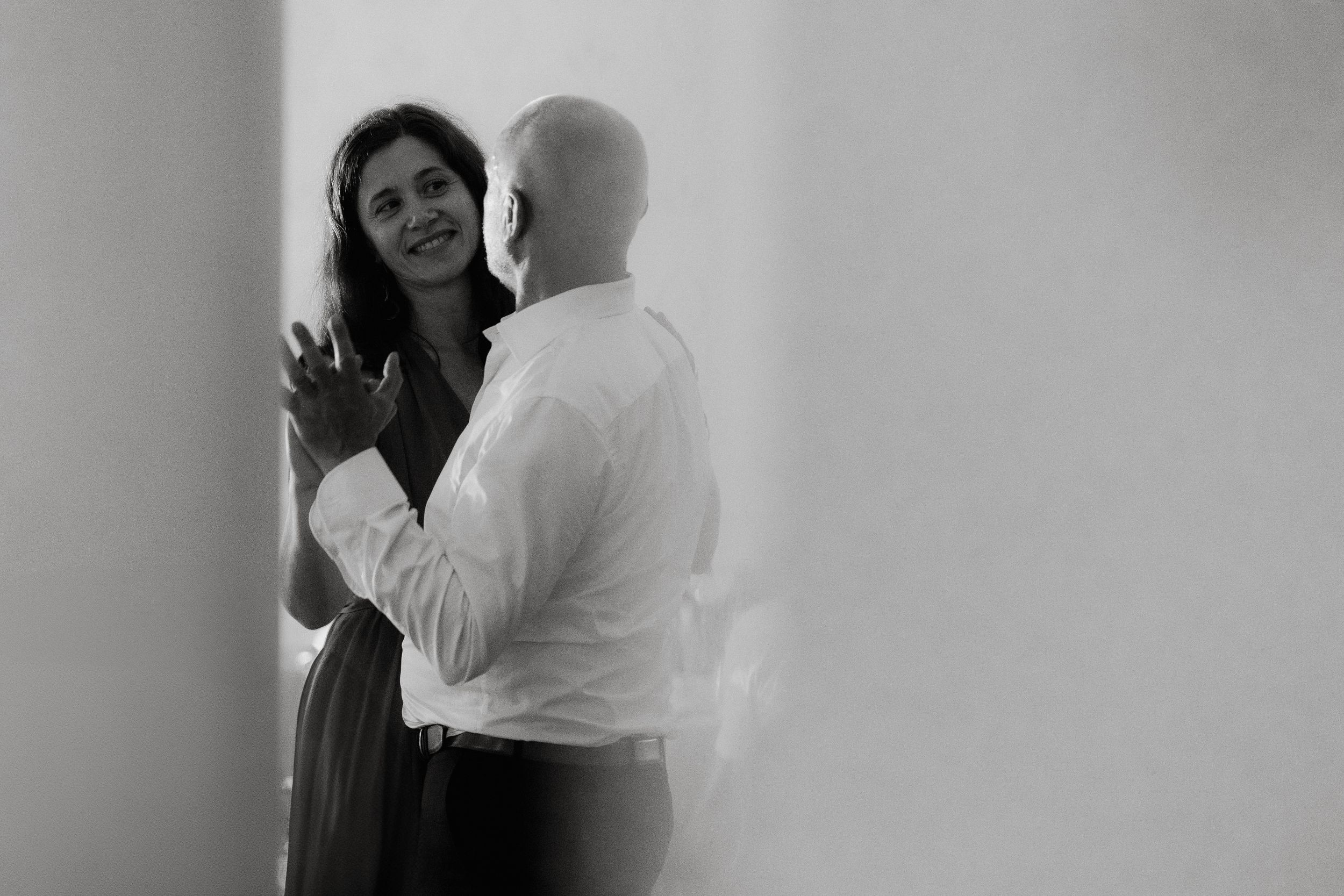 A romantic black and white moment captured of a couple dancing together in an intimate setting.