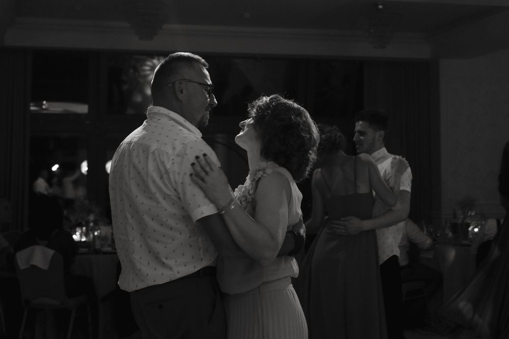 Couples slow dancing together at an evening event in black and white photography.