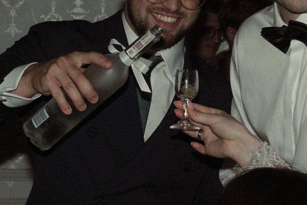 A group of people in formal wear toast with champagne glasses at an elegant celebration.