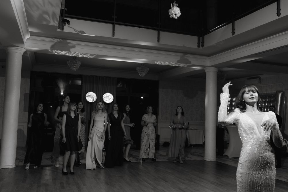 Wedding guests gather on a dance floor for a classic group dance number at a wedding reception.