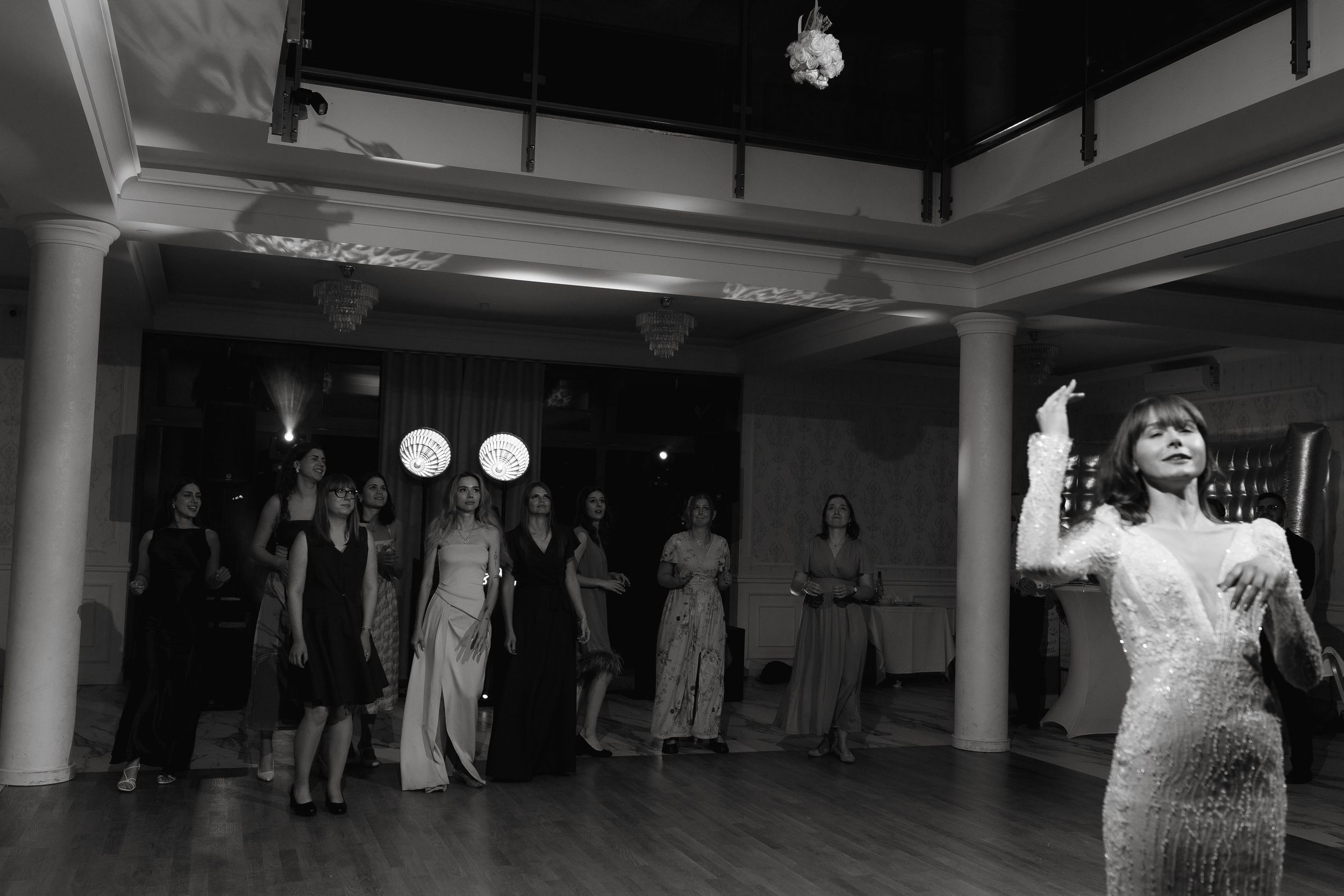 Wedding guests gather on a dance floor for a classic group dance number at a wedding reception.