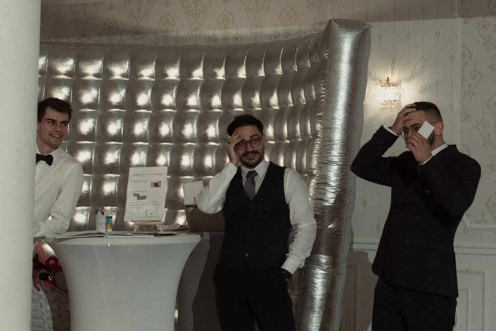 A long strip of four black and white photobooth style snapshots showing posed moments in sequence.