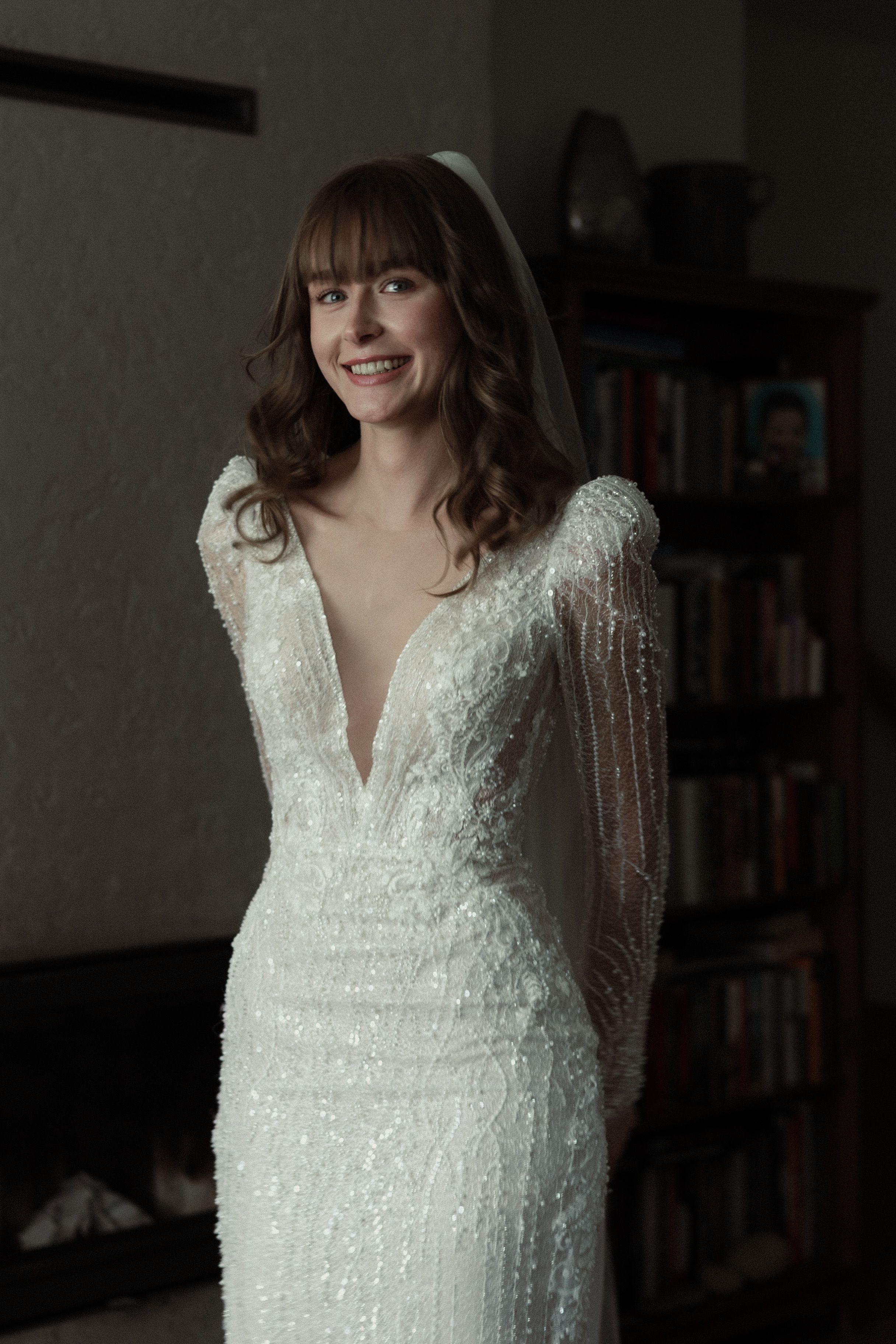 A modern wedding dress with sequins and delicate V-neckline shown in a series of detail shots against dark background.
