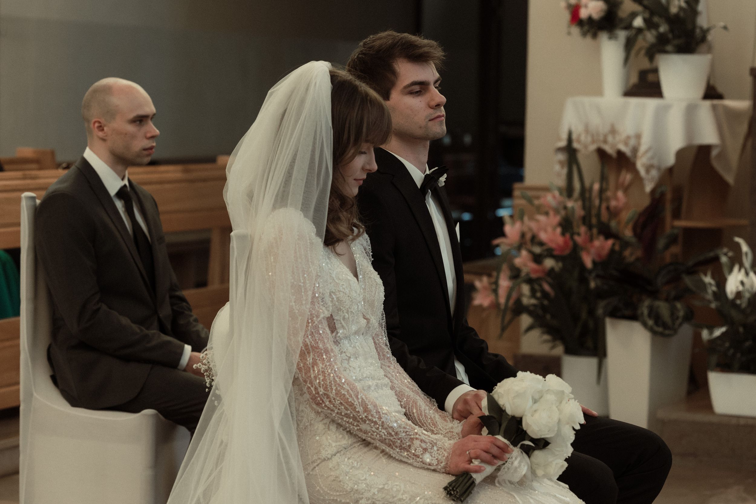 Romantic candid moments from wedding ceremony showing intimate exchanges between couple in a church setting.