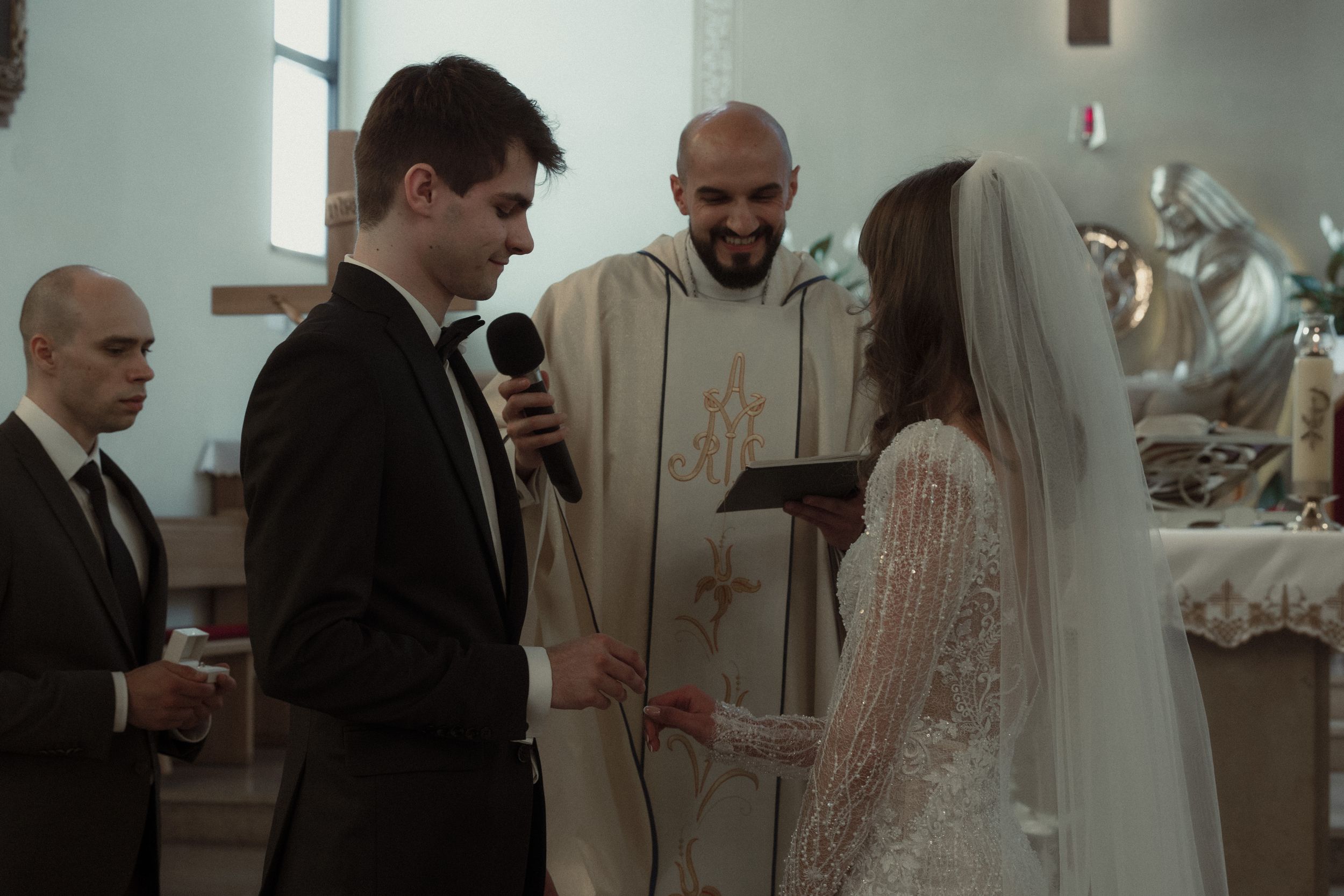 The bride and groom share an intimate first dance as newlyweds at an elegant church wedding reception.