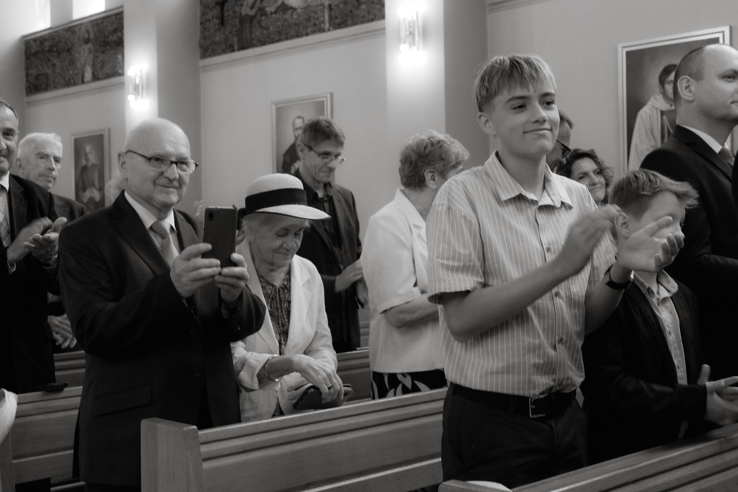 Black and white photograph of people standing in church pews during a worship service.