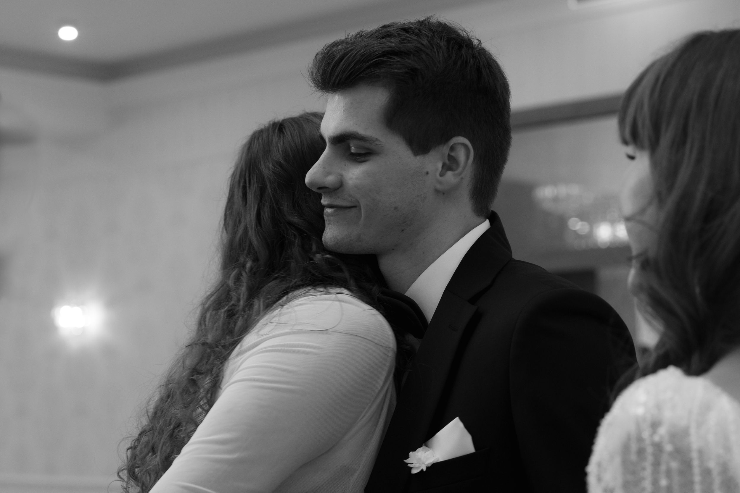 A romantic black and white photo of a couple dancing close together at an elegant indoor event.