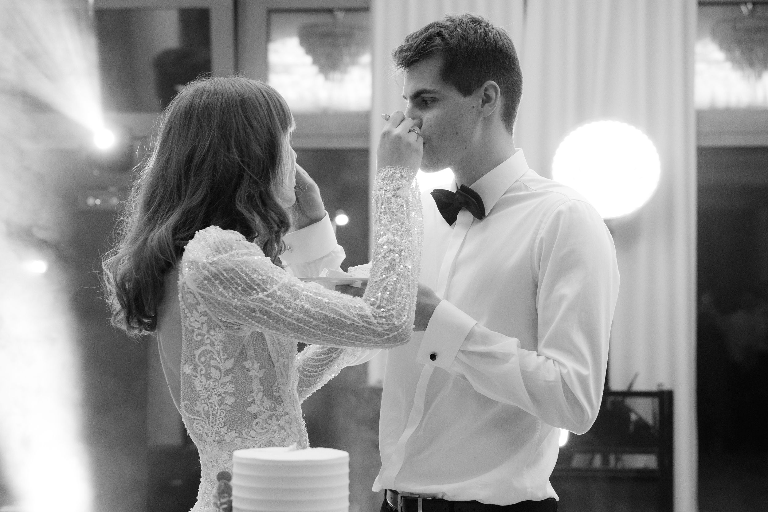 A bride and groom share their first dance at a wedding reception in black and white photography.