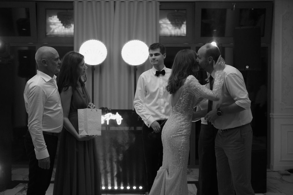Black and white photo of a small group engaged in conversation at an evening gathering.