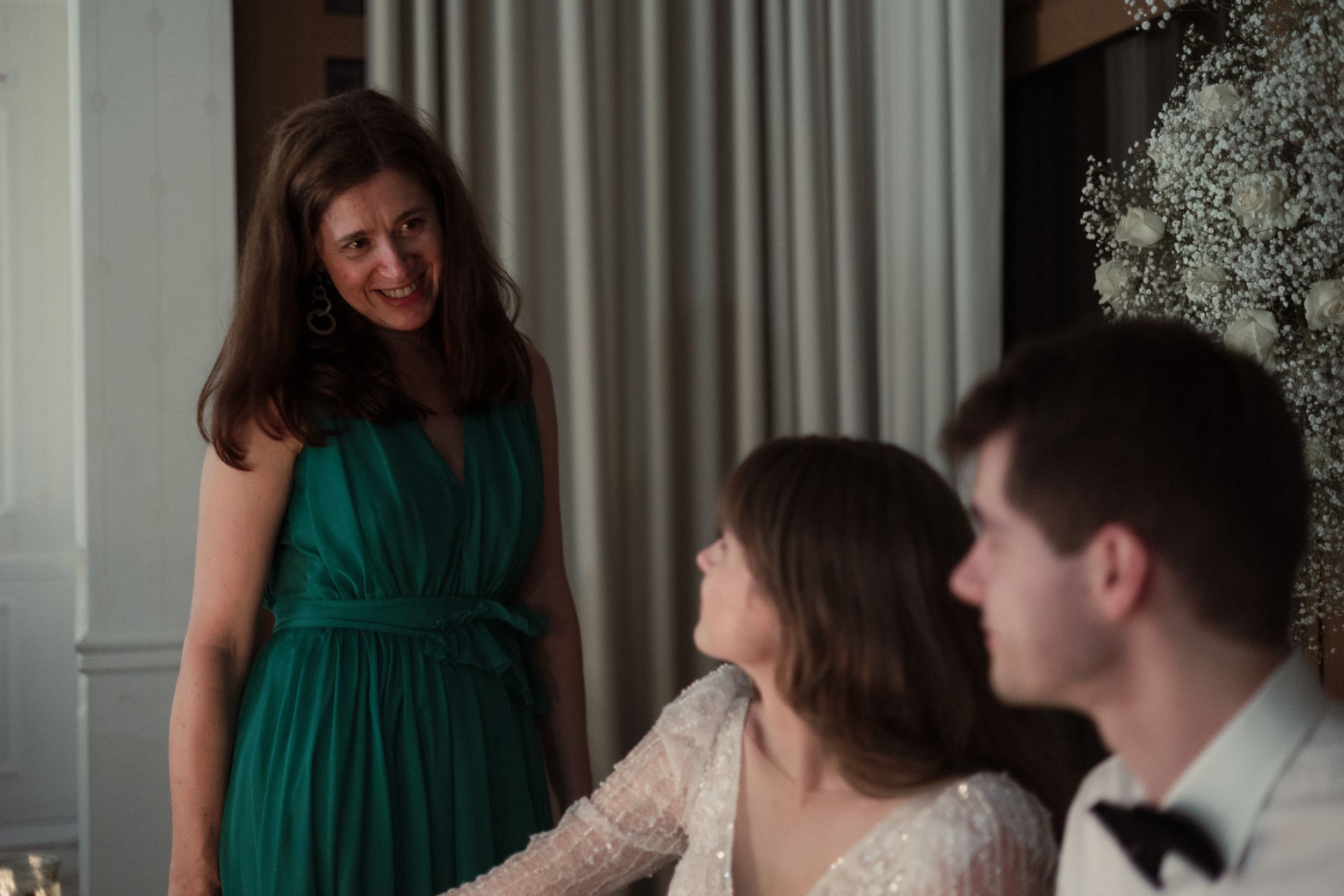 Five connected images show a happy celebration gathering as people interact and chat together in a bright indoor setting.