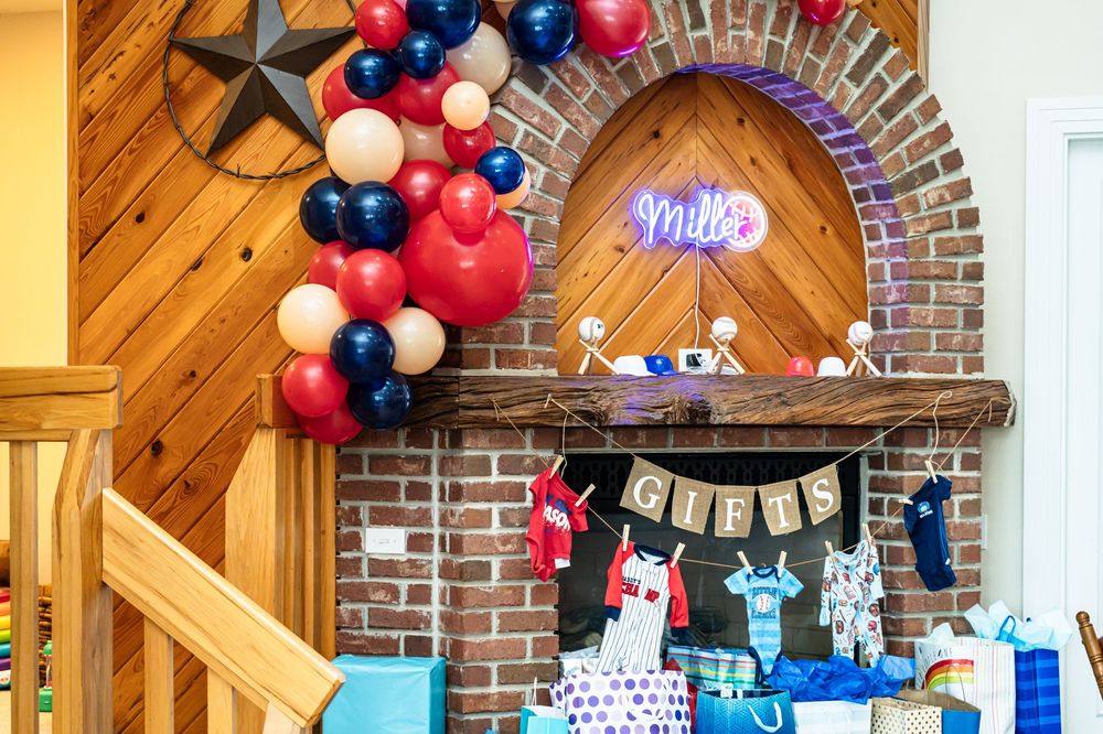 Sports-themed celebration display with balloon garland and gift table setup.
