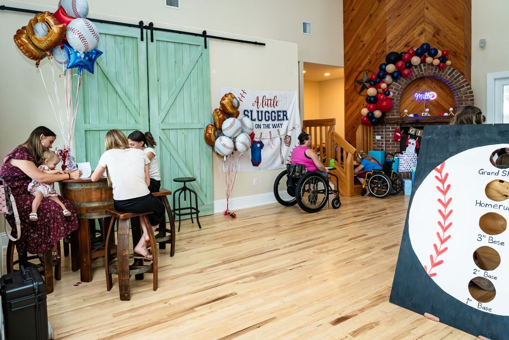 Party room with wooden floors and decorative balloons near turquoise barn doors.