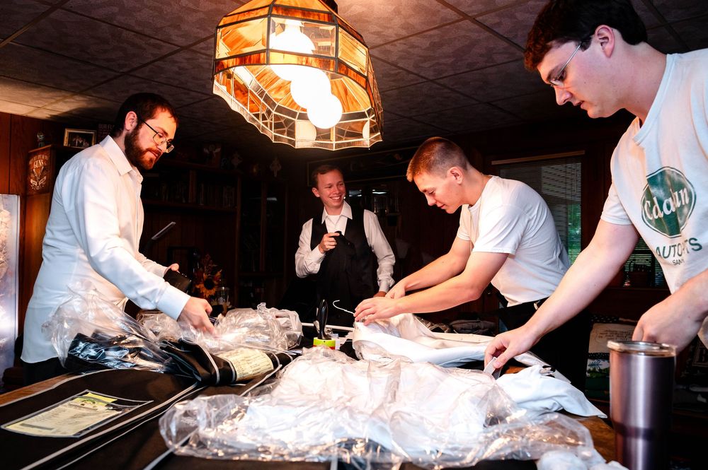 Chefs preparing and carving large fish in restaurant kitchen.