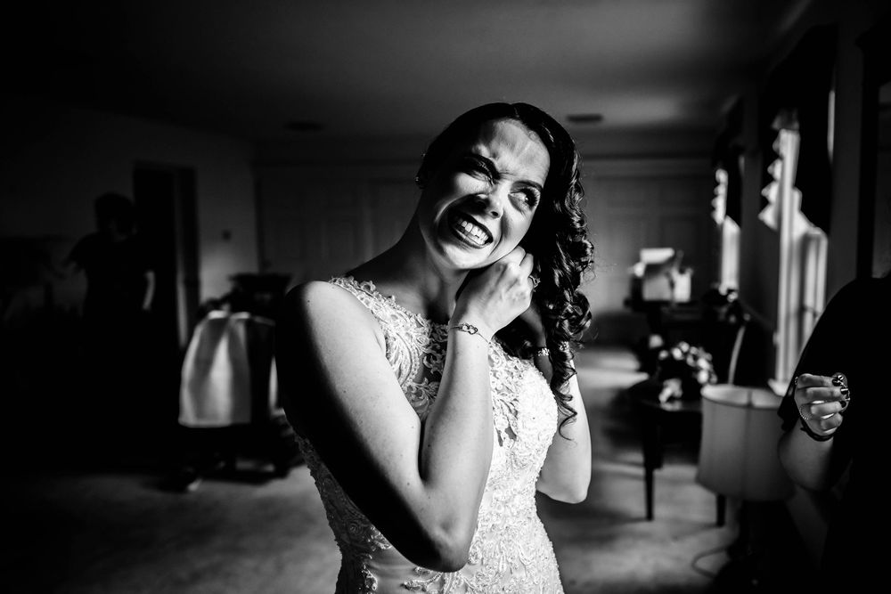 Black and white portrait of person in lace dress laughing.