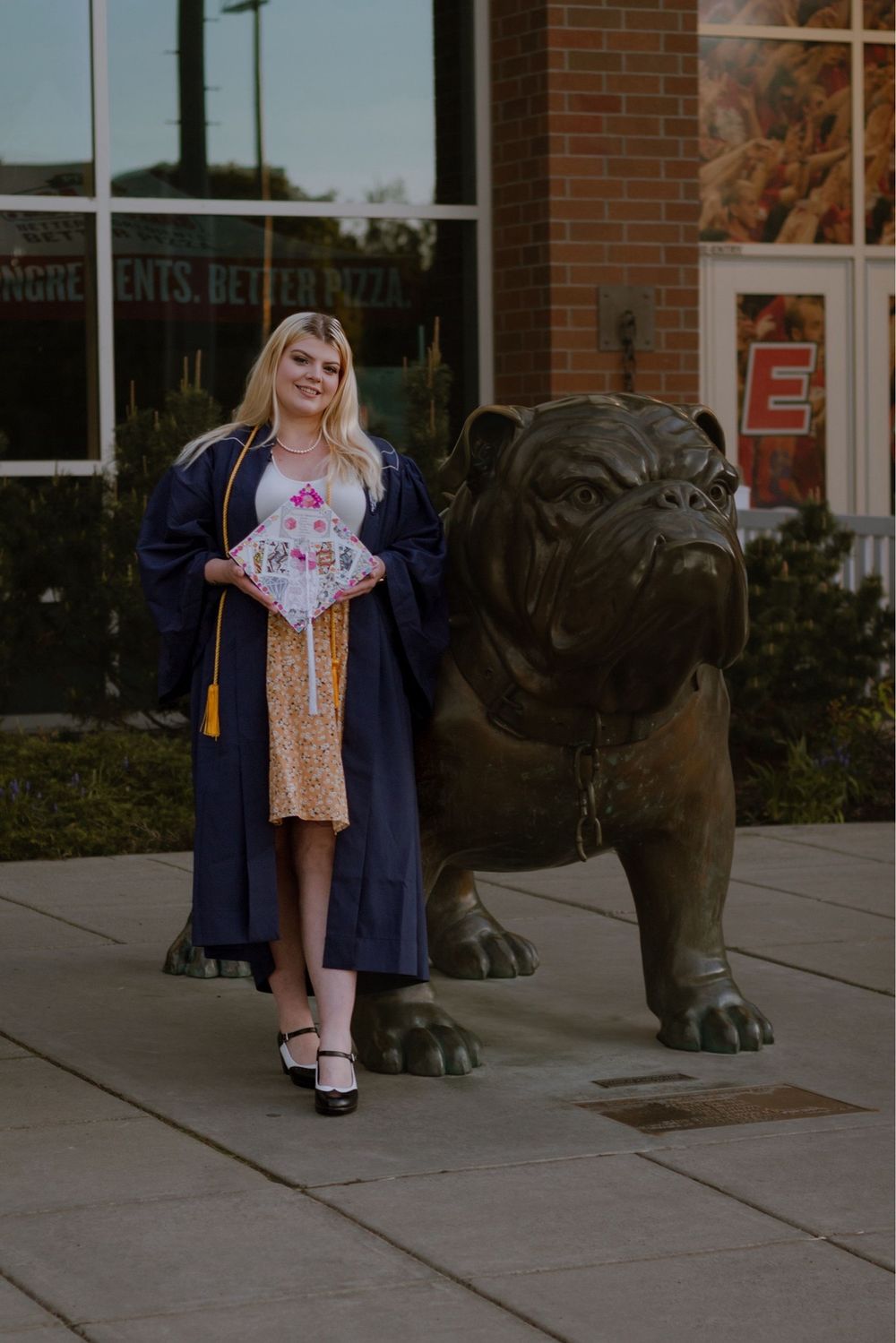 Spokane WA college graduate near mascot statue.
