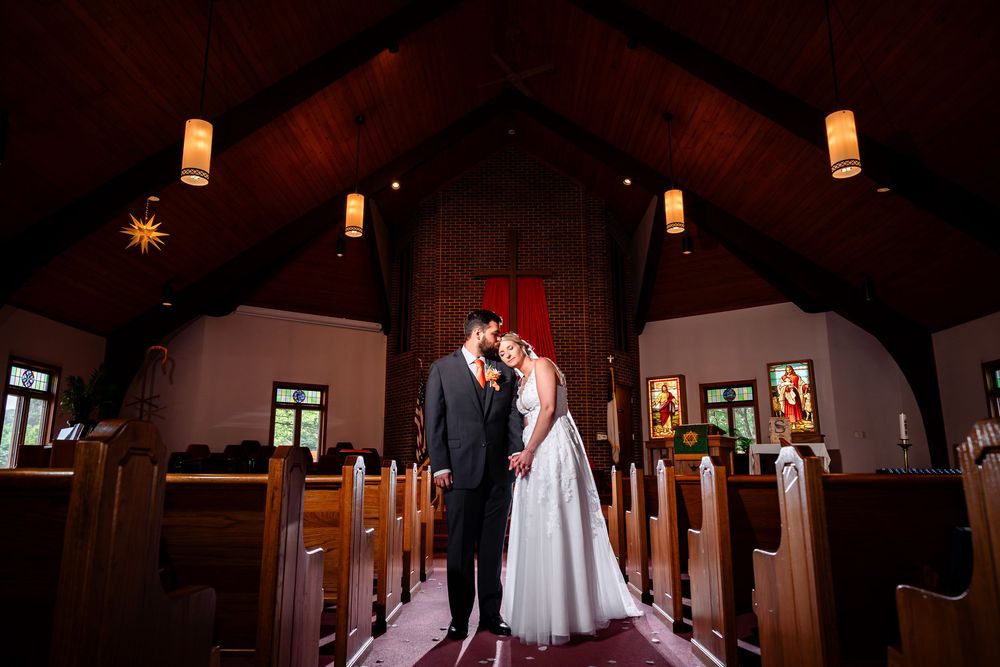 Wedding ceremony in a dimly lit church with warm ambient lighting.
