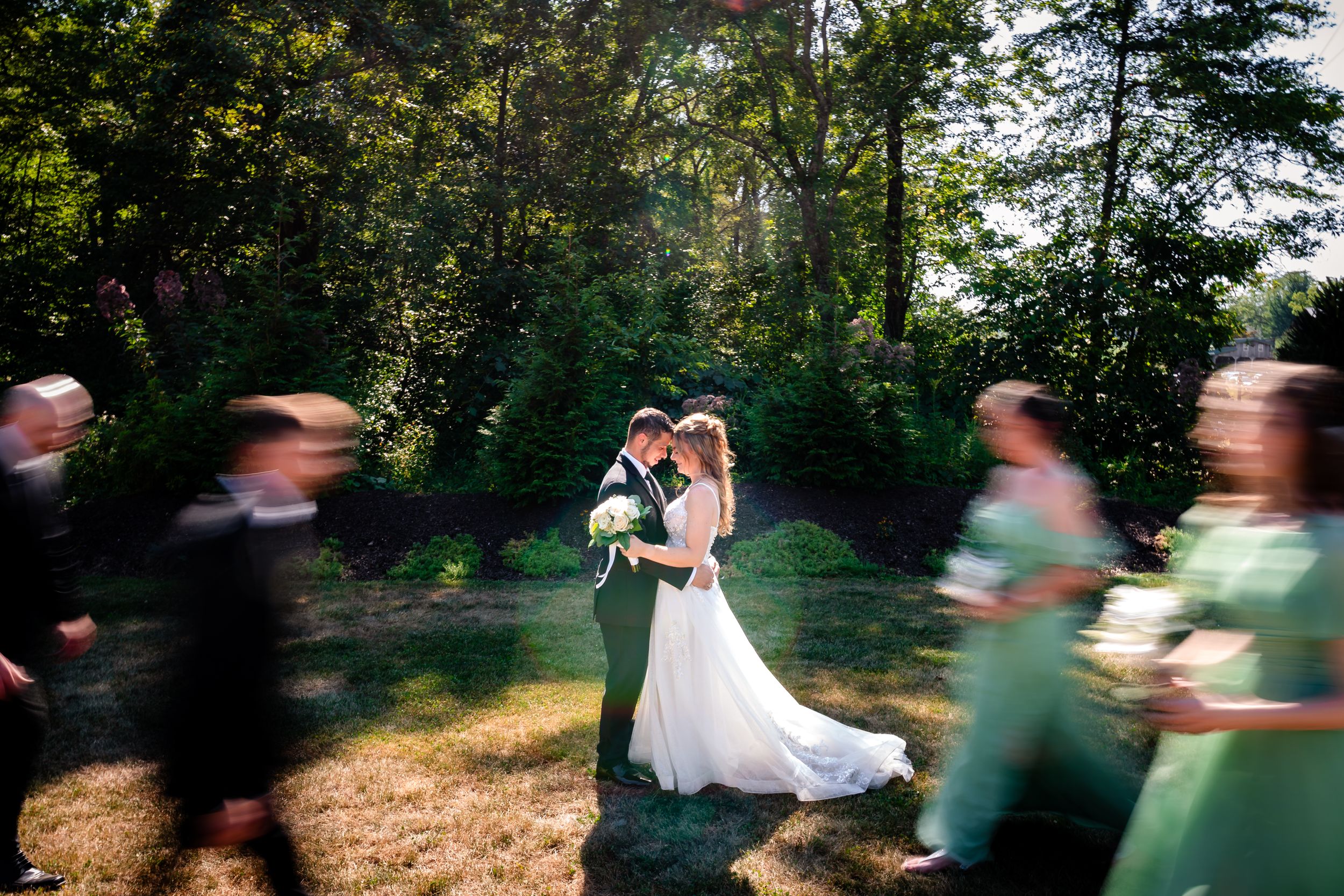 Wedding party creates motion blur effect during outdoor photo session.