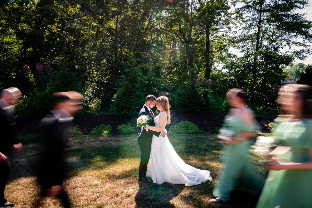 Wedding party creates motion blur effect during outdoor photo session.